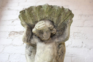 An Attractive Early 20thC Stone Pedestal Birdbath in the Form of a Robed Youth Supporting a Clamshell