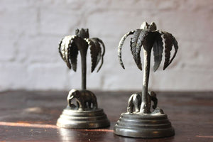 A Whimsical Pair of Victorian Bronzed Metal Candlesticks Each Formed as an Elephant Before a Palm Tree