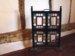 An Arts and Crafts Coloured Glass & Ebonised Fire Screen