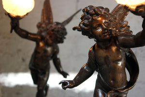 After Emile Bruchon (1806-1895); ‘L’Amour Vainquer’ & ‘L’Amour Vagabond’; An Attractive Pair of French Spelter & Marble Table Lamps Modelled as Winged Cherubs c.1915