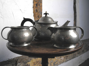 An Art Nouveau Liberty's Pewter Tudric Three Piece Tea Set, No. 01075, attributed to Archibald Knox